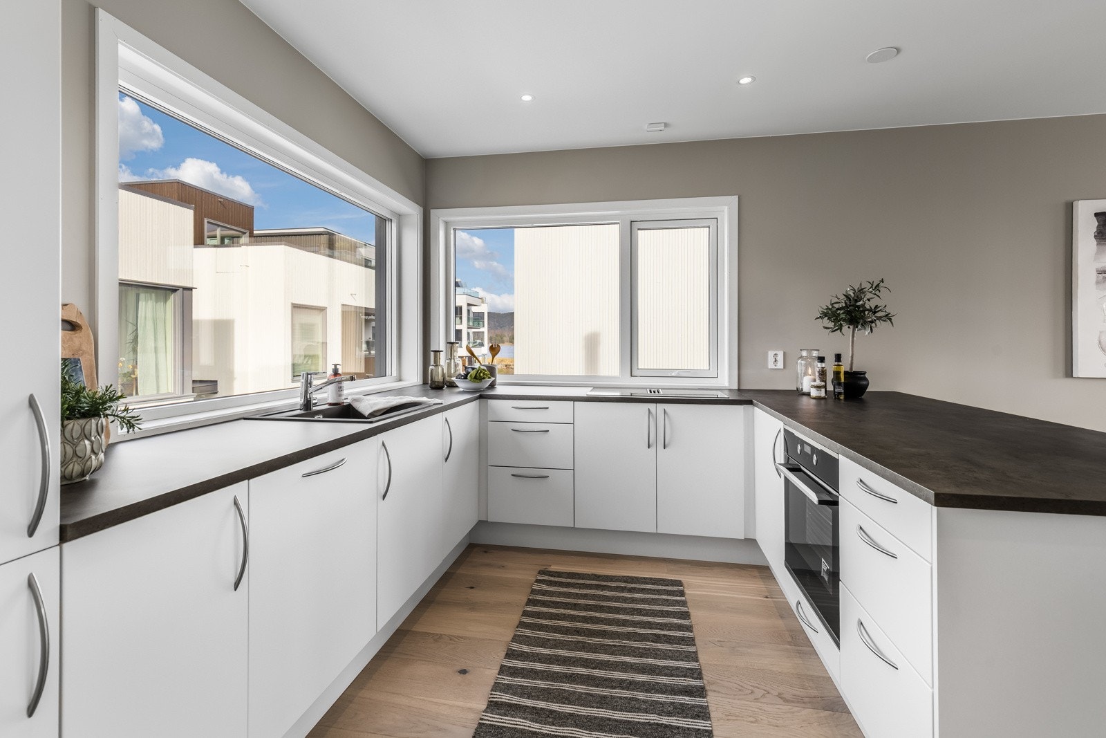 Kjøkkenet er oppført i en smart u-form med god skap- og benkeplass. Galleribilde