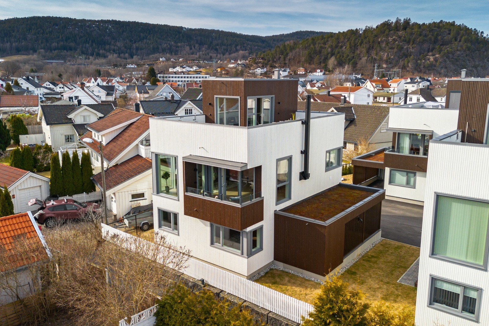 Selve tomten er solrik og tilnærmet flat, med gressplen, hvitmalt gjerde og belegningsstein. Galleribilde