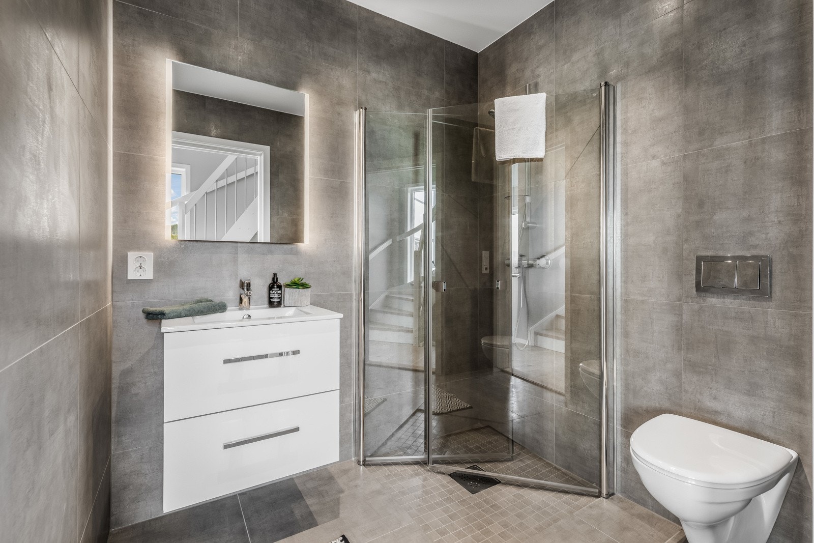 Det andre badet har store grå vegg- og gulvfliser. Galleribilde