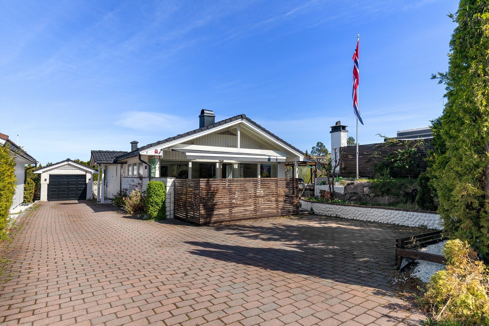 Parkering for en bil i garasje samt god plass på stensatt gårdsplass Galleribilde