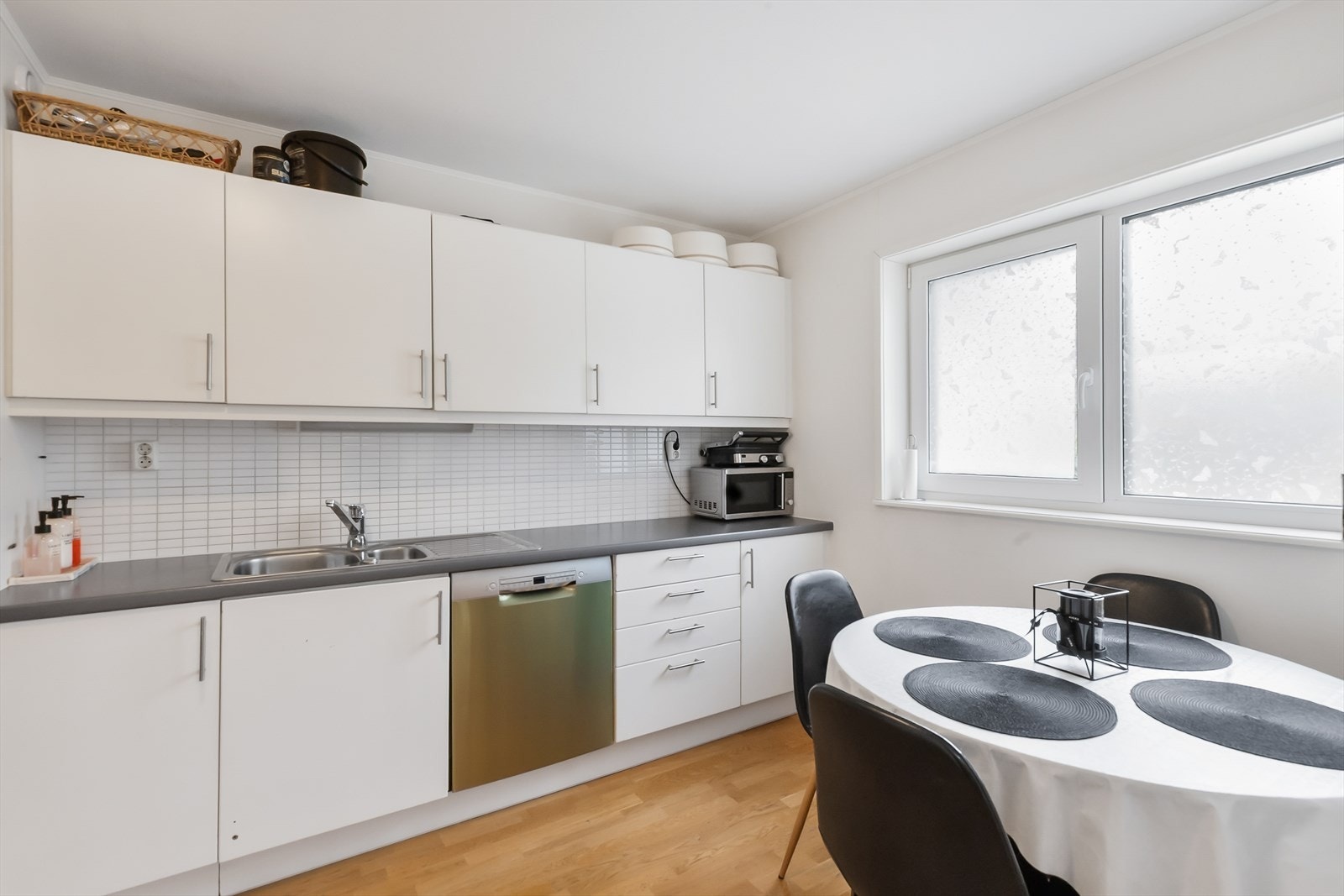 Lyst og funksjonelt kjøkken med plass til spisebord ved vinduet Galleribilde