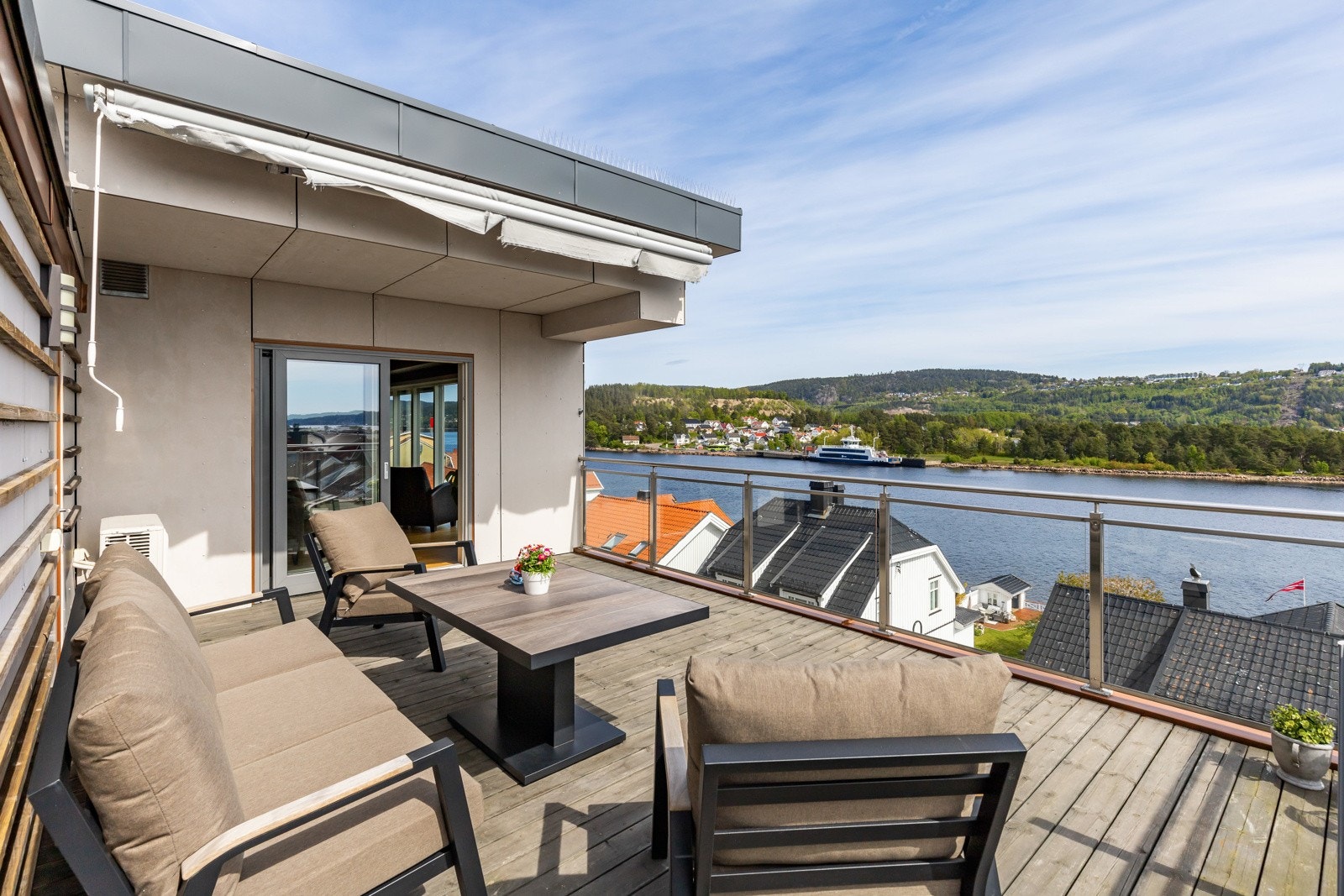 Romslig terrasse med utsikt over vannet og omkringliggende landskap. Galleribilde