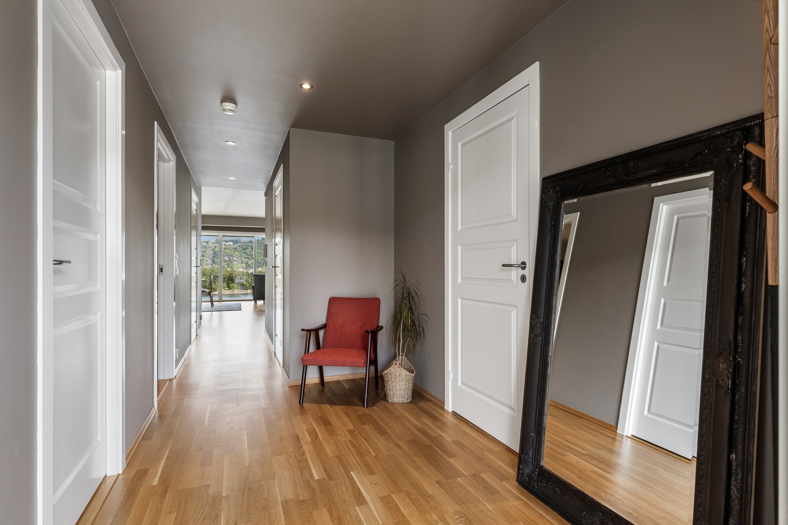 Lys og innbydende gang med parkettgulv og lyse vegger. Galleribilde