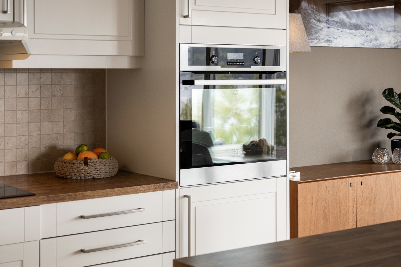 Moderne kjøkken med integrert ovn og lyse fronter. Galleribilde