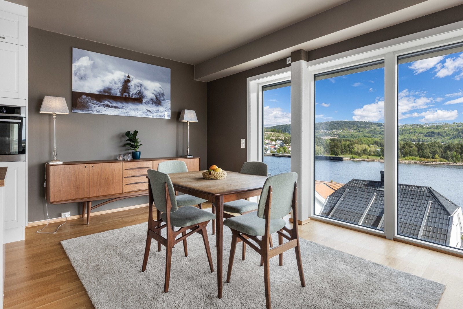 Lyst rom med store vinduer som gir flott utsikt mot fjorden og grønne omgivelser. Galleribilde