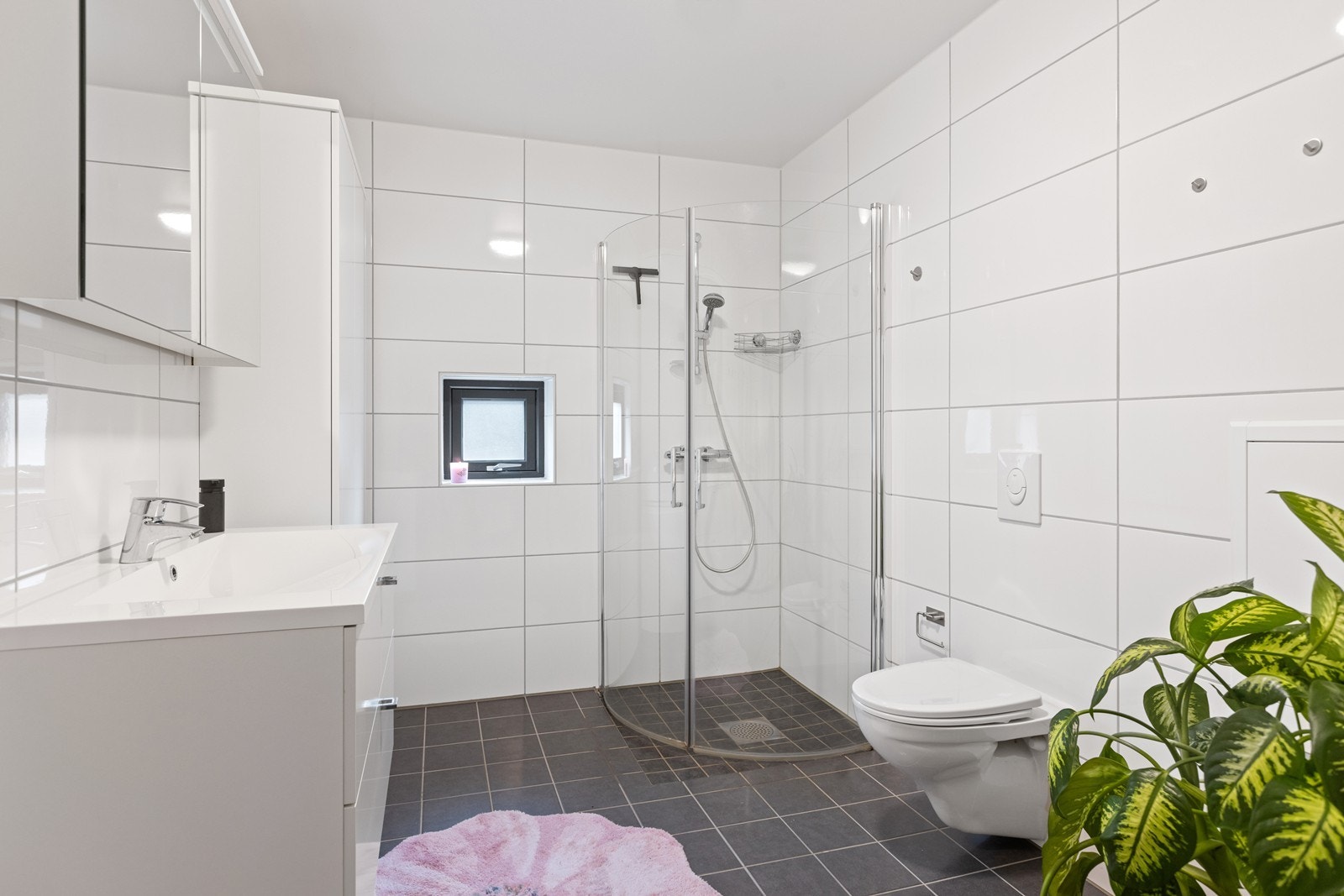 Delikat bad med flislagte overflater, varme i gulv og moderne innredning. Galleribilde