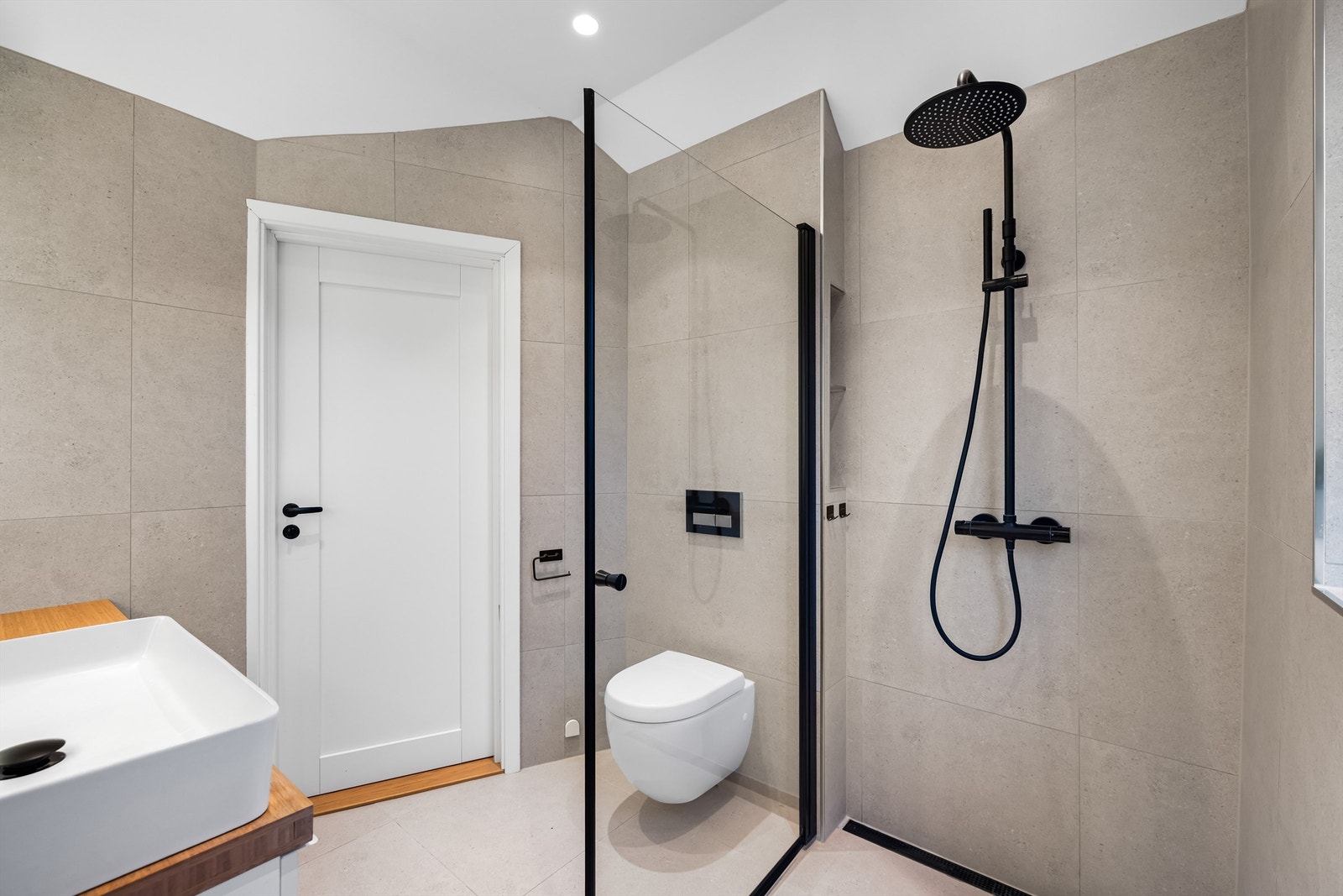 Rommet er utstyrt med vegghengt toalett og et dusjhjørne med glassvegg Galleribilde