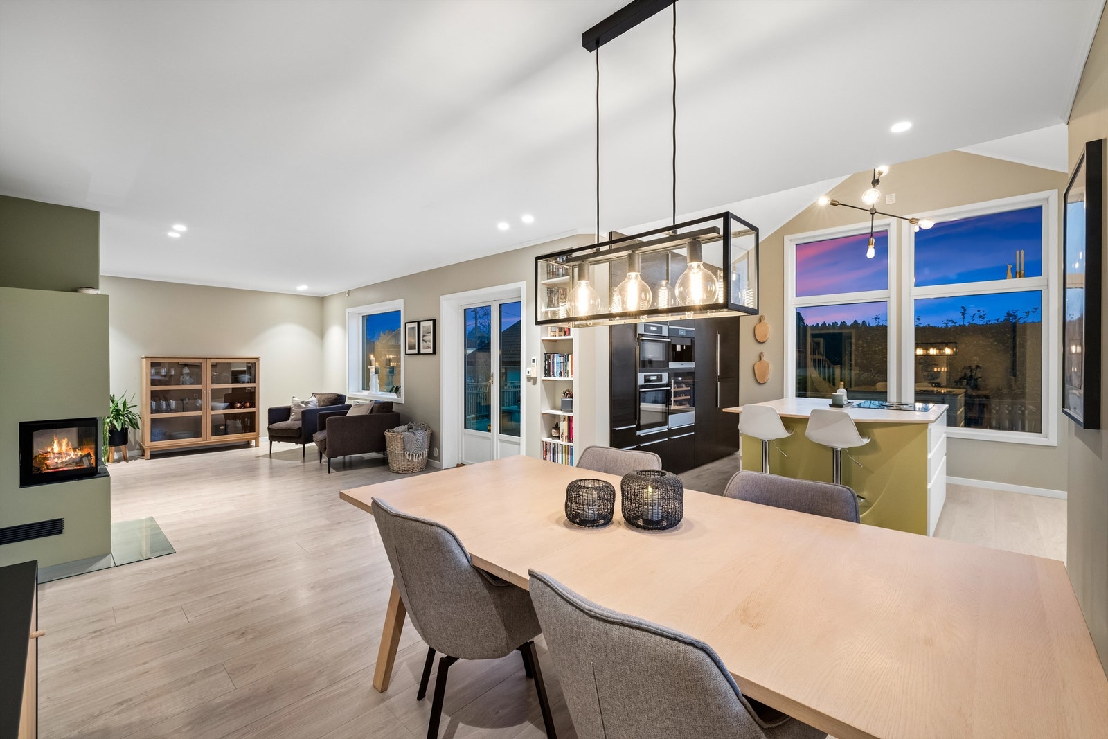 Boligens sosiale sone består av en åpen løsning mellom stue, spisestue og kjøkken Galleribilde