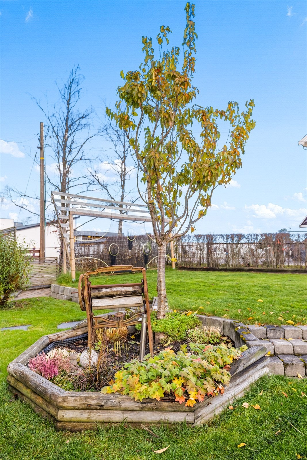 Tomten er pent opparbeidet med beplantning og steinbelagte ganger Galleribilde