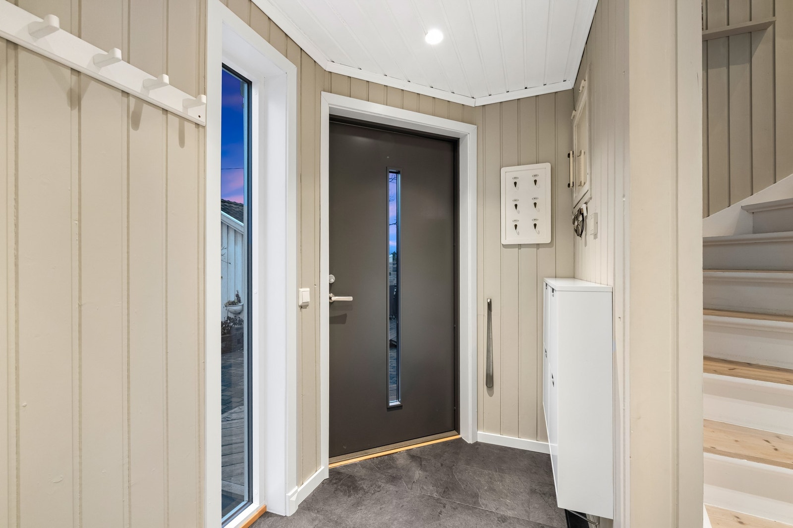 Velkommen inn i en lys entré med adkomst til boligens hovedplan Galleribilde