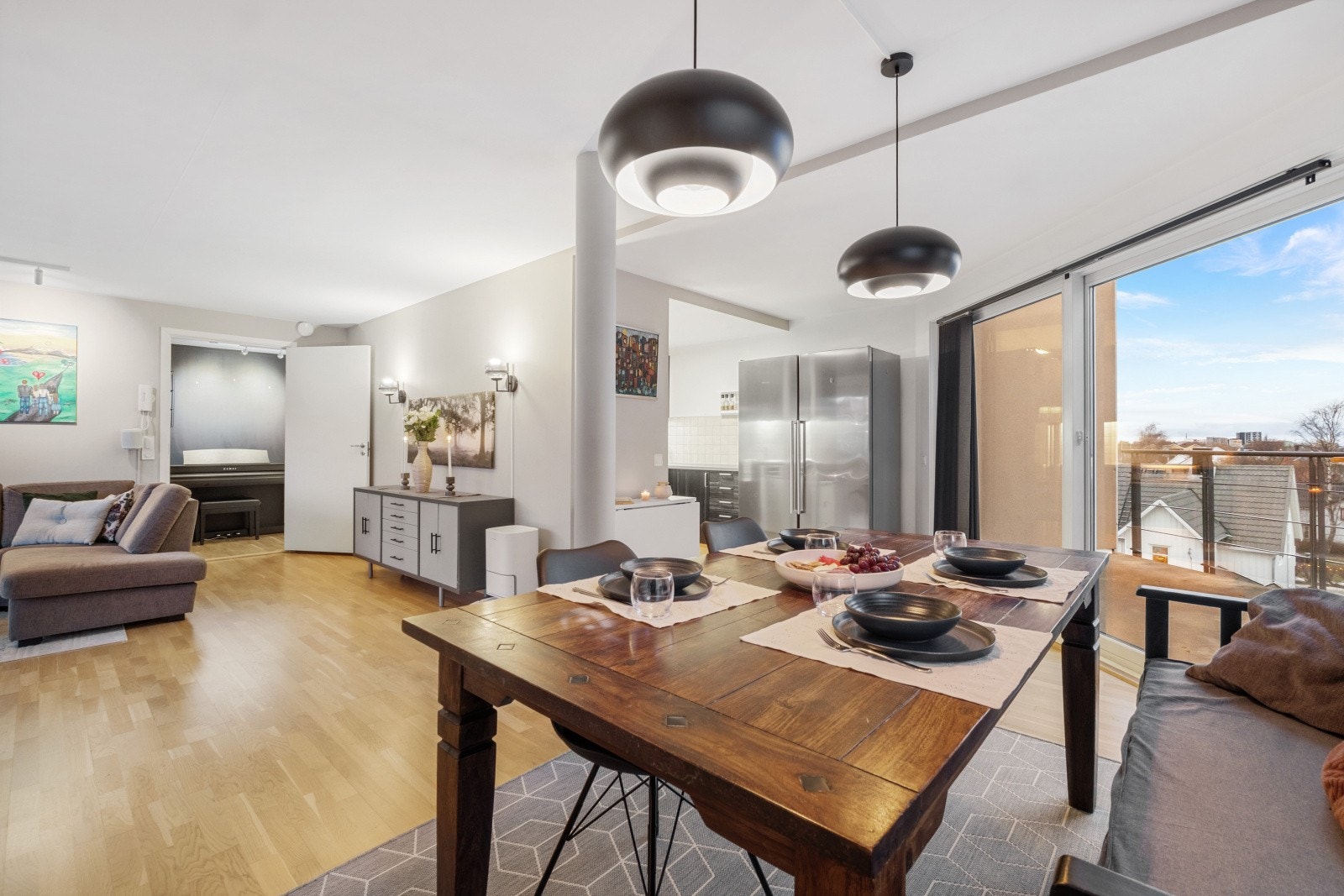 Åpen løsning mellom stue og kjøkken gjør rommet praktisk for sosiale sammenkomster. Galleribilde