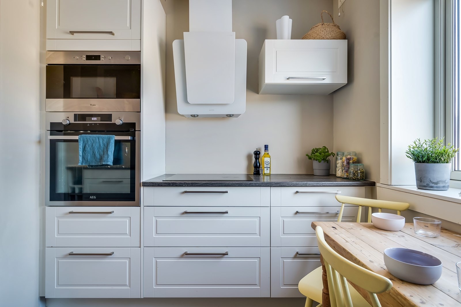 Kjøkkenet utstyrt med integrerte hvitevarer som stekeovn, platetopp, mikrobølgeovn og oppvaskmaskin, samt plass til frittstående kjøl-/fryseskap Galleribilde