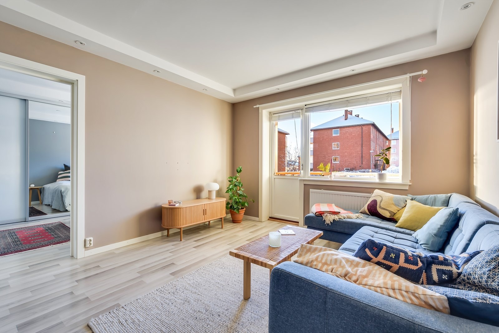 Stuen er malt i en delikat fargetone, og gulvet er dekket med laminat Galleribilde