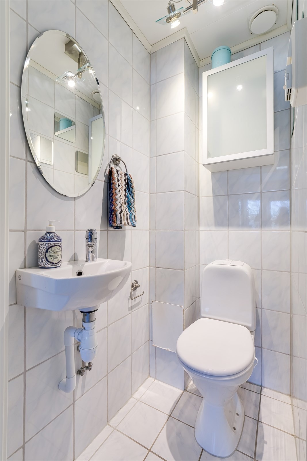 Separat toalettrom med flislagte overflater, vask og toalett Galleribilde