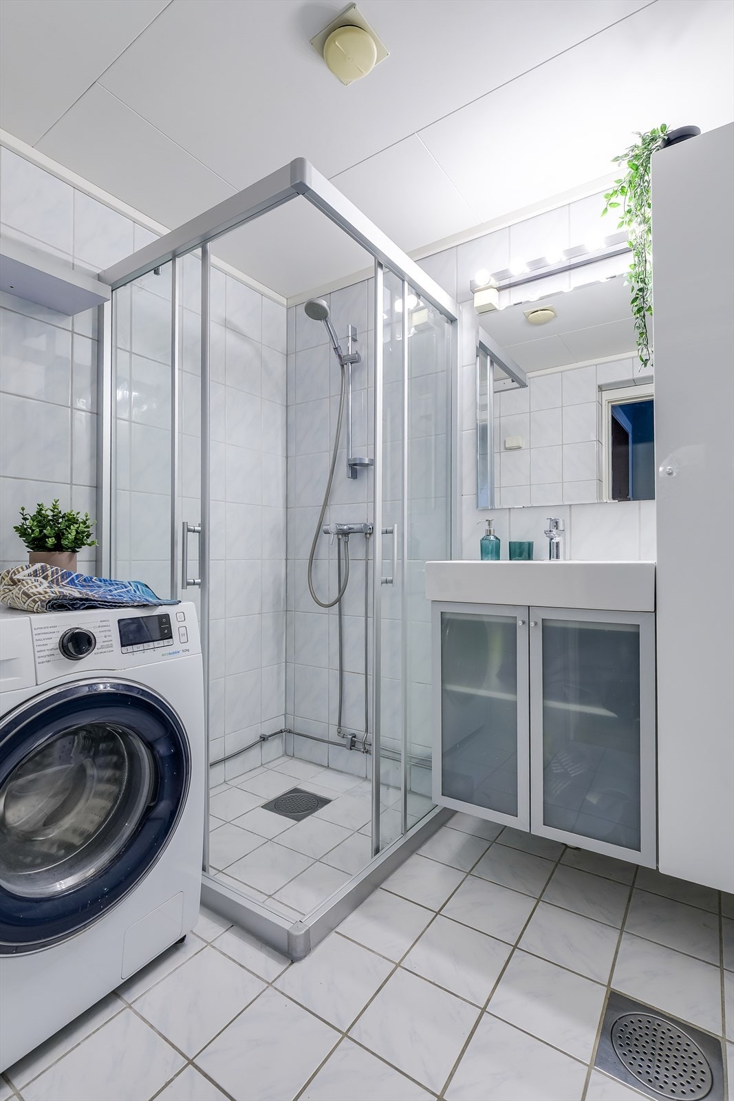 Badet er innredet med servantskap med nedfelt servant, speil og dusjhjørne Galleribilde