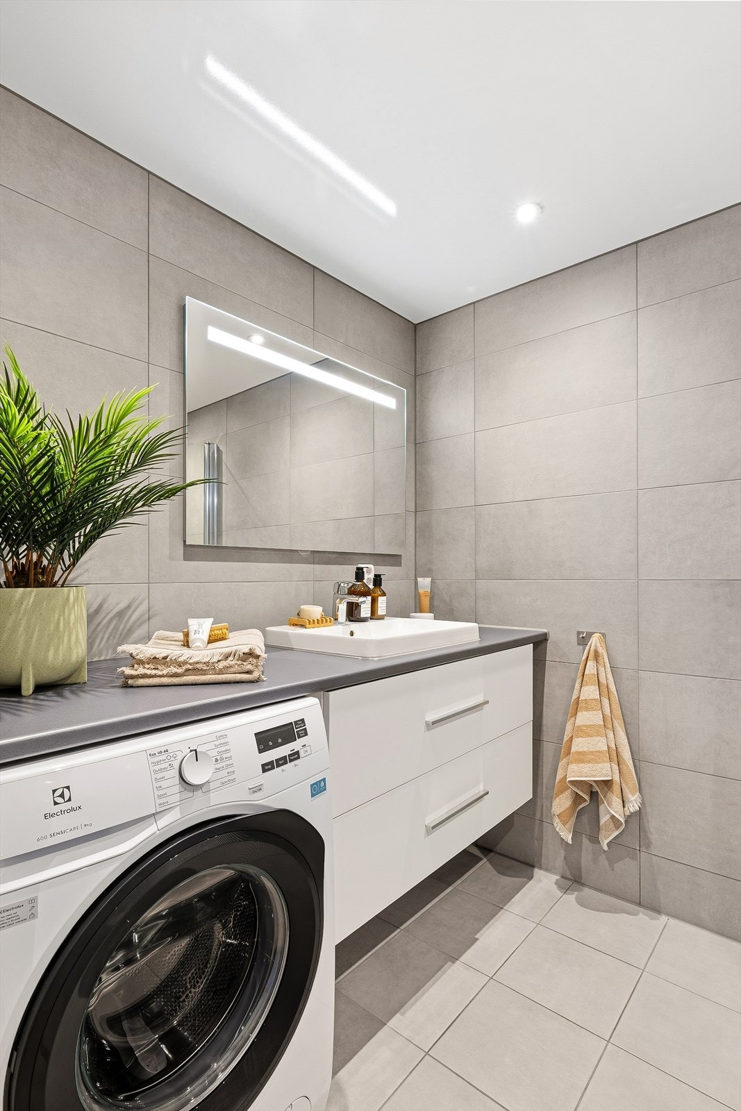 Vegghengt servantinnredning og opplegg for vaskemaskin. Vaskemaskinen vil medfølge salget. Galleribilde