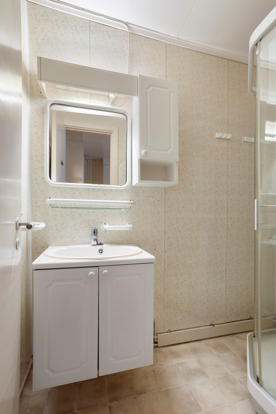 Badet er utstyrt med innredning med nedfelt servant, vegghengt speil og dusjkabinett Galleribilde