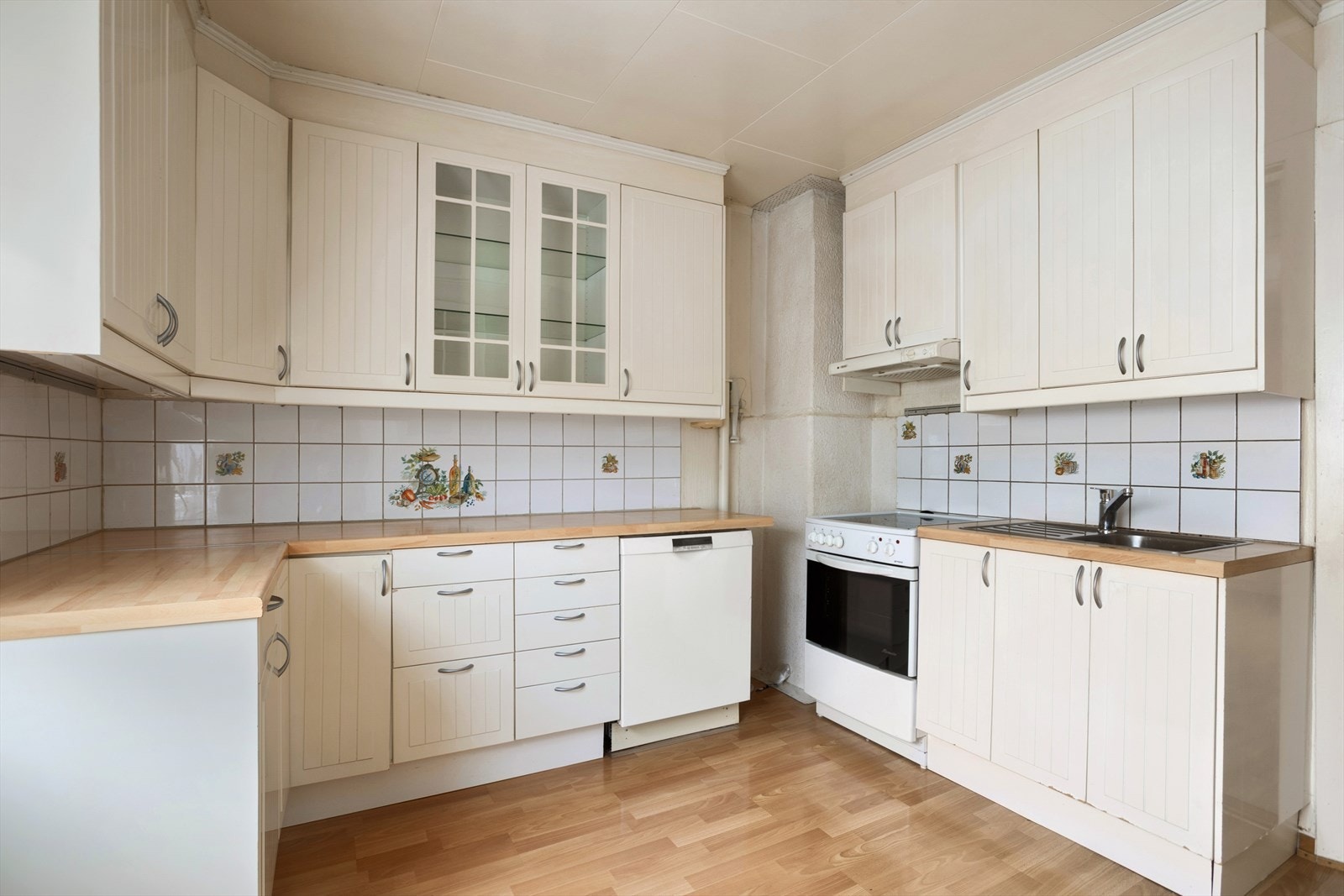 Kjøkkenet har profilerte fronter, flislagt over kjøkkenbenk og benkeplate i laminat Galleribilde