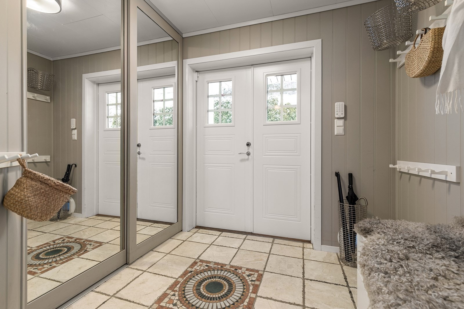 Velkommen inn! Her kommer man inn i en lys og romslig entré med god plass til oppbevaring av sko- og yttertøy i skyvedørsgarderobe. Entrén har gulvvarme. Galleribilde