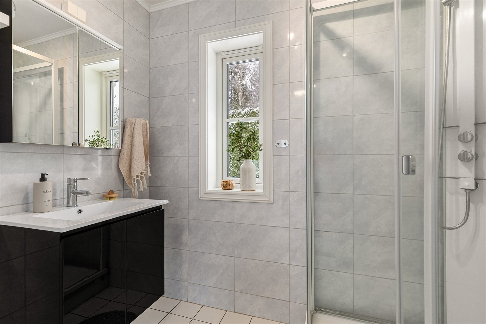 Det andre badet, plassert ved vaskerommet, har gulvvarme og er innredet med servant med servantskap og dusjkabinett. Galleribilde