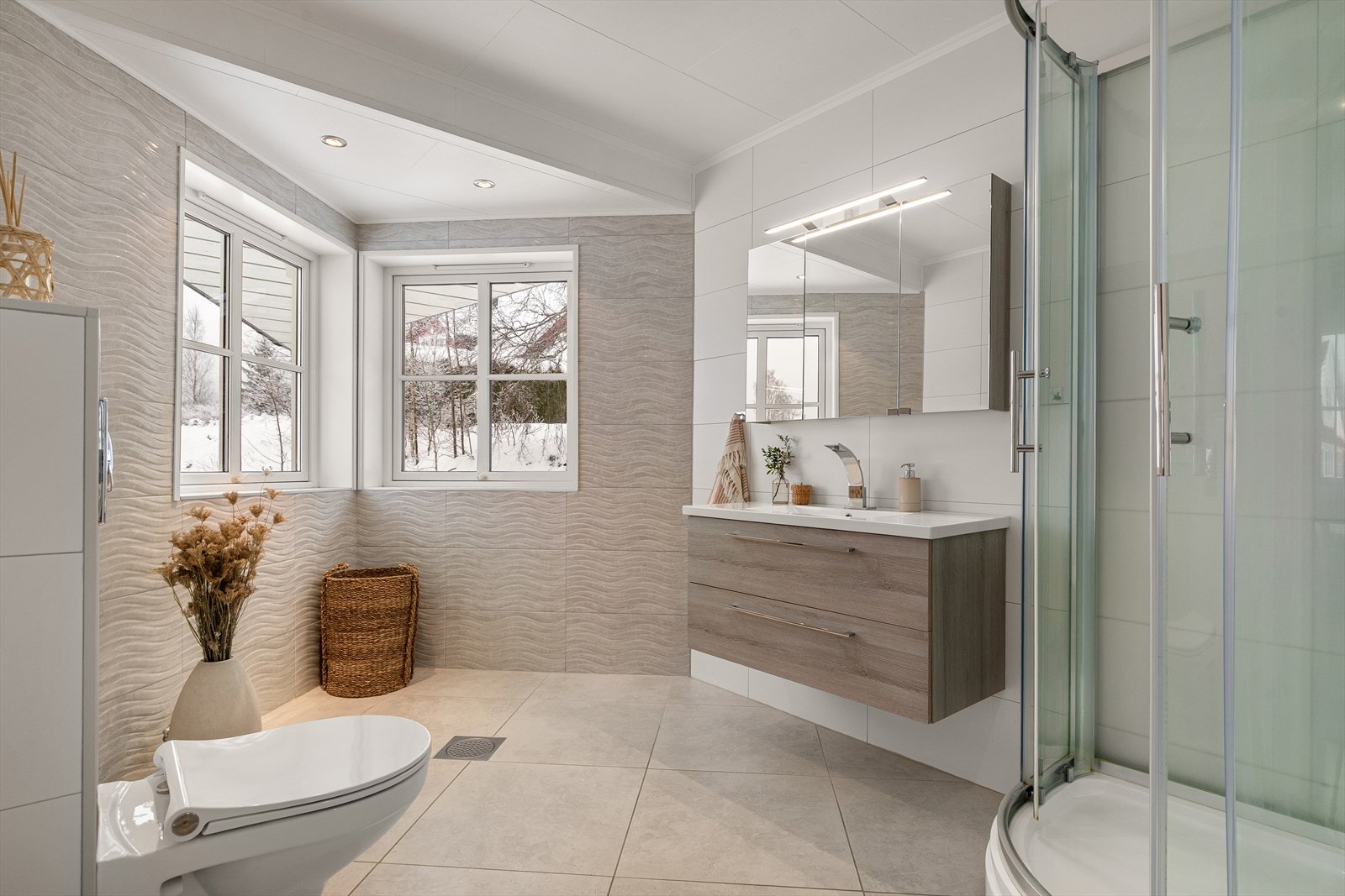 Badet tilknyttet hovedsoverommet er flislagt og utstyrt med gulvvarme, servant med servantskap og dusjkabinett. Galleribilde