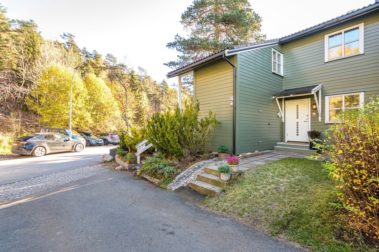 Felles tomt for borettslaget opparbeidet med blant annet asfalterte internveier, parkeringsplasser, gressplen, trær, prydbusker og diverse beplantning. Galleribilde