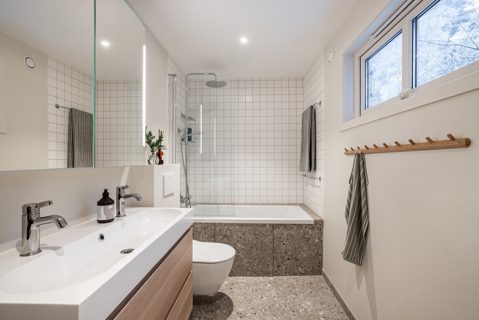 Boligen har et lyst og moderne baderom som ble oppgradert i 2023. Moderne baderomsinnredning med skuffer og heldekkende dobbel servant, speilskap med integrert belysning over. Galleribilde