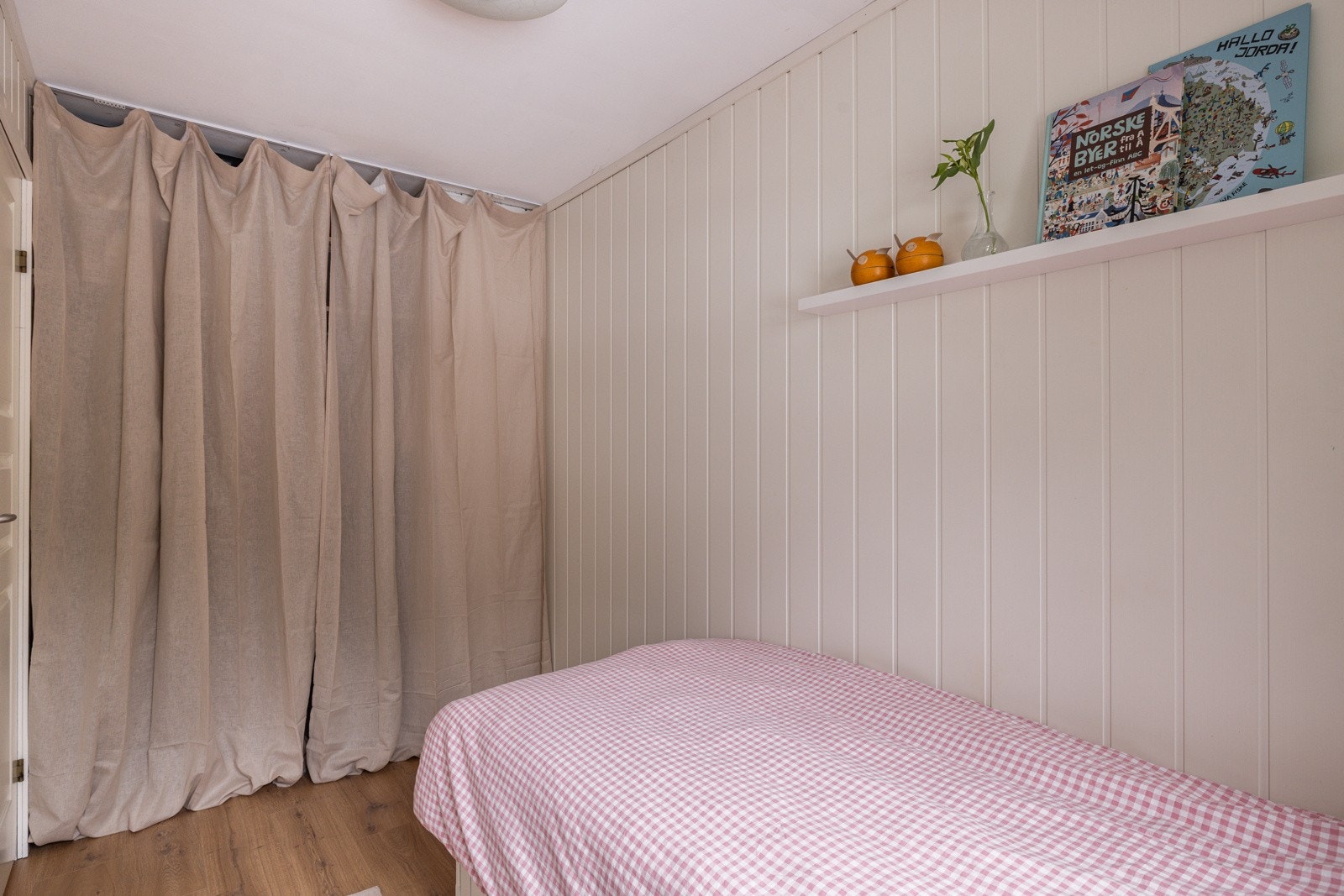 Soverommet har moderne enstavs laminat på gulv og lysmalte panelplater på veggene. Galleribilde