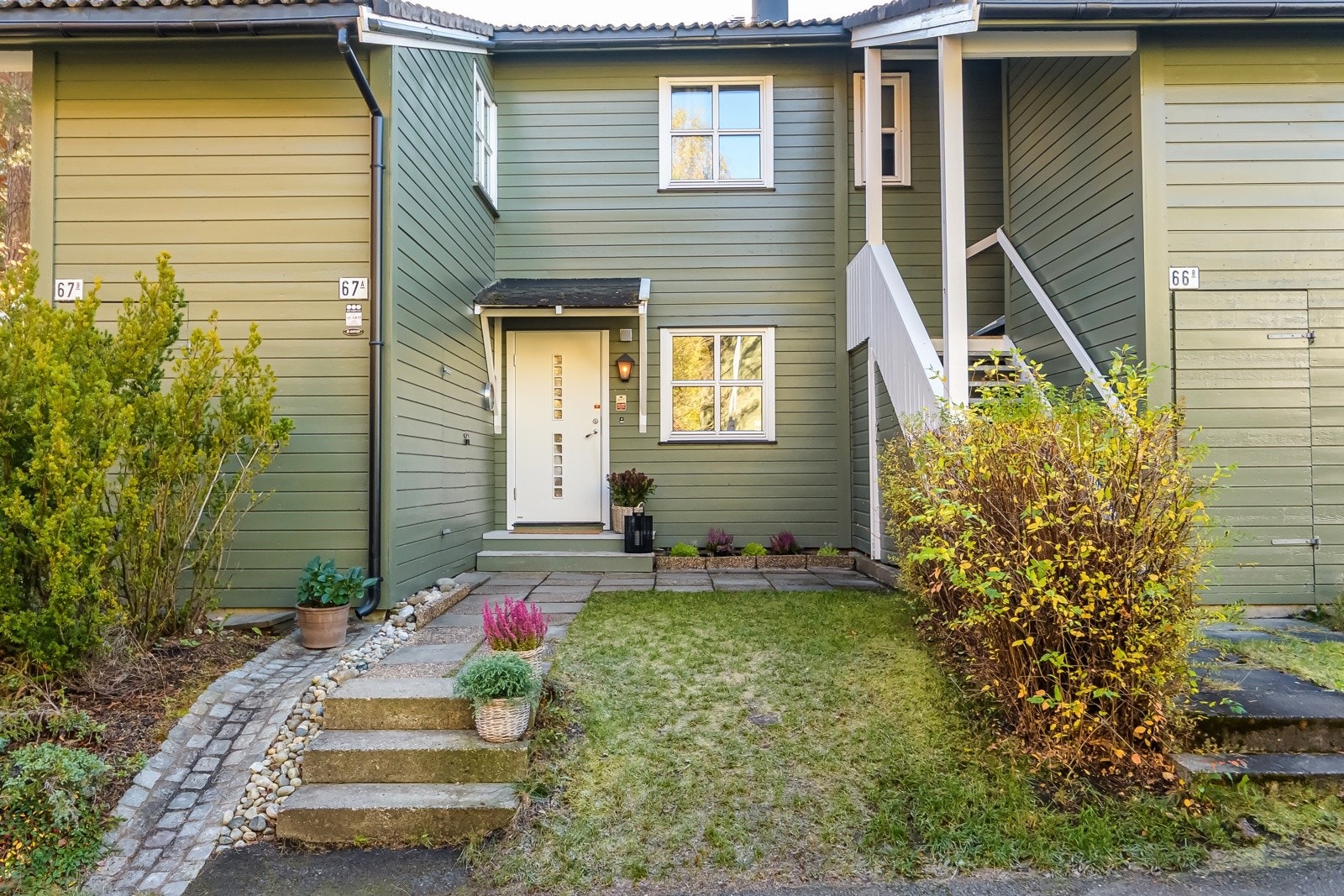 Du ønskes velkommen inn via et hyggelig inngangsparti som er opparbeidet med plen, betongheller og blomsterbed. Galleribilde