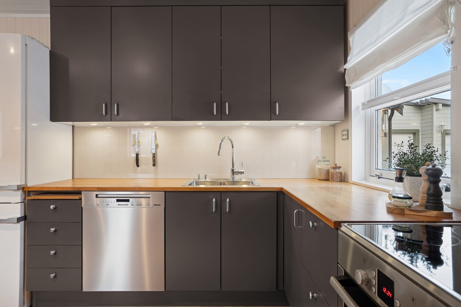 For en praktisk matlagingsopplevelse er det montert belysning under overskapene, en glassplate på veggen bak koketoppen og ventilator over kokesonen. Galleribilde