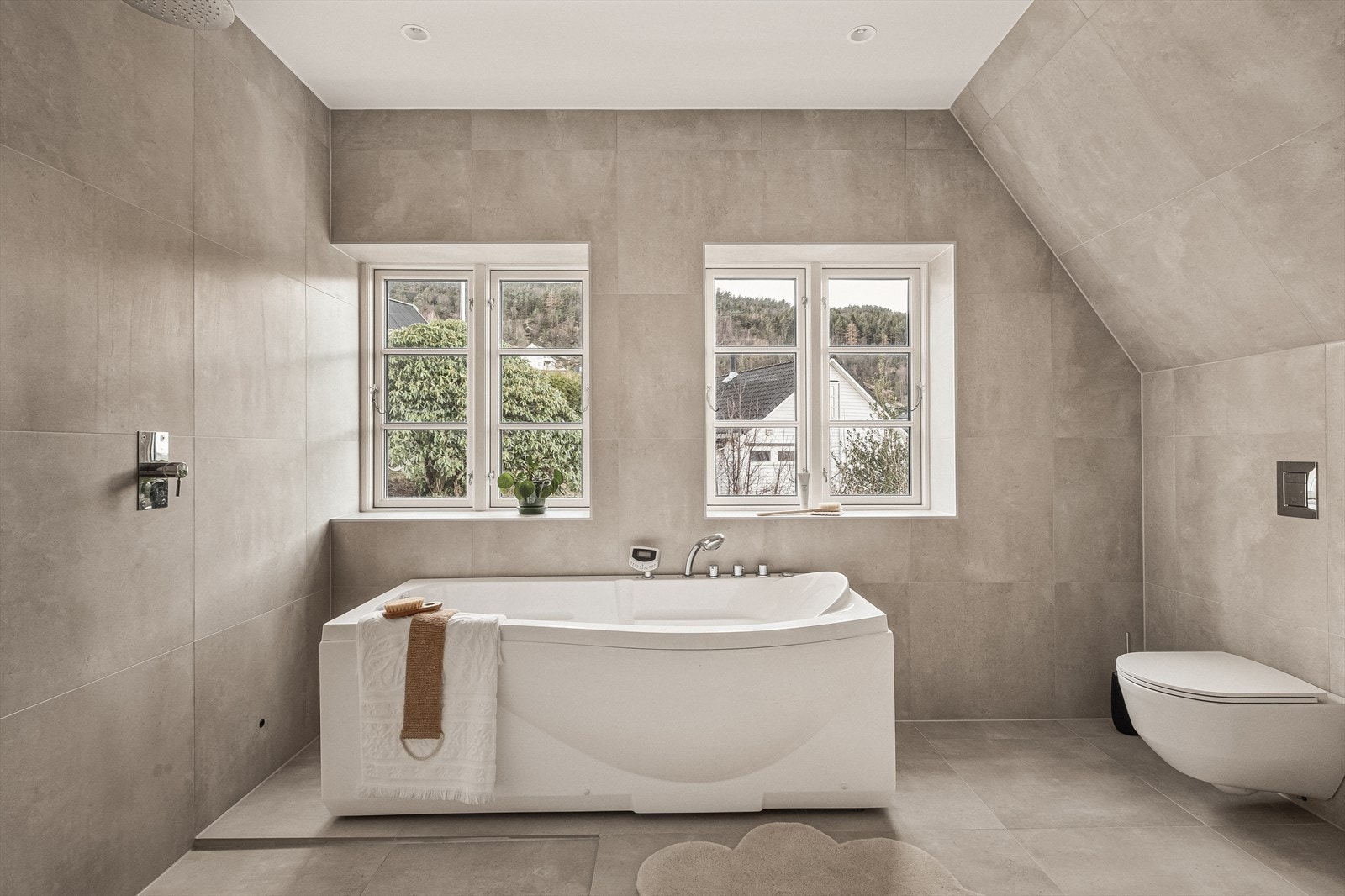 Badet er romslig og stilrent, med store fliser, moderne innredning og et flott badekar som gir en eksklusiv spa-følelse til rommet. Galleribilde