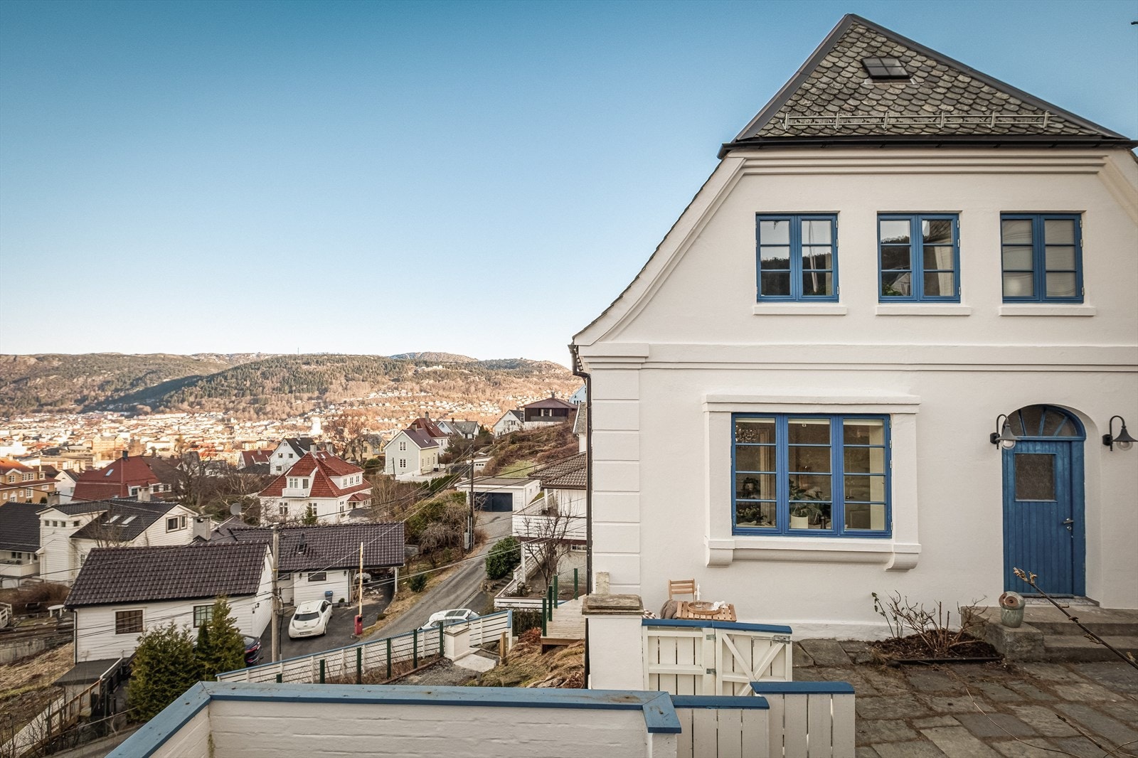 Boligens inngangsparti er pent opparbeidet med skiferplatting, trapp og diverse beplanting. Det er støttemurer og hagemurer i naturstein, samt grus og treterrasser rundt bygget. Galleribilde