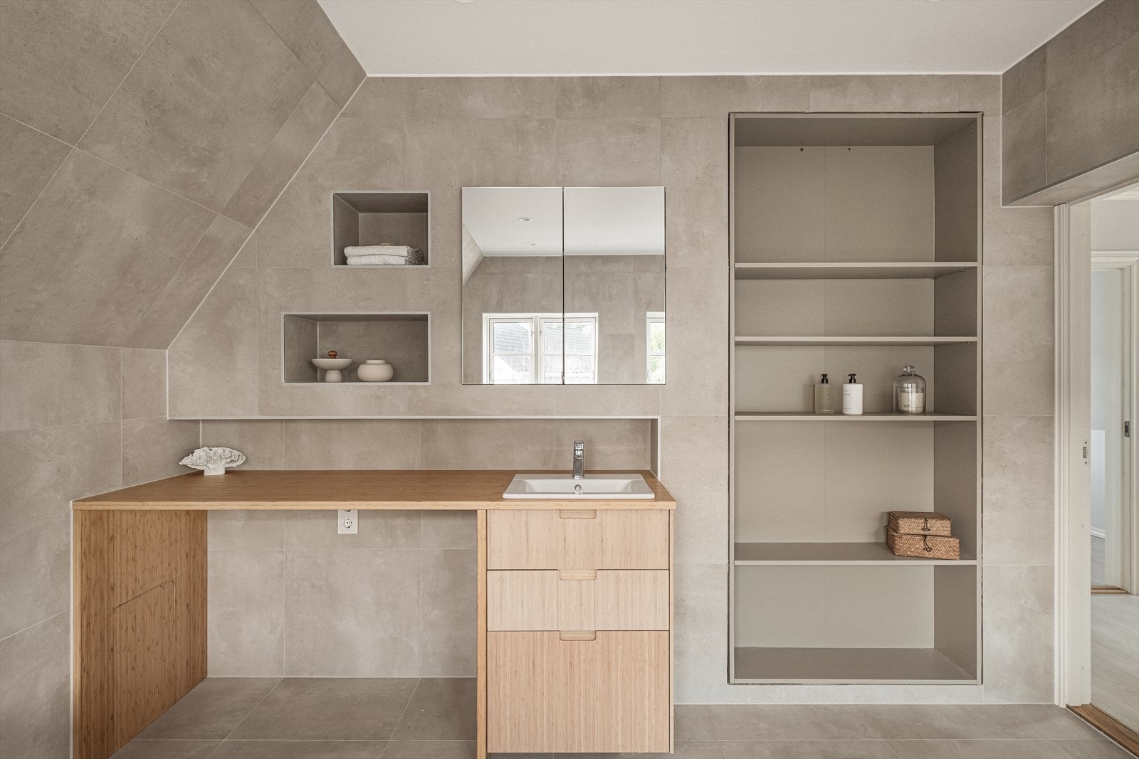 Foruten om badekaret er baderommet innredet med dusj, servant med møbel, veggmontert toalett og opplegg for vaskemaskin. Galleribilde