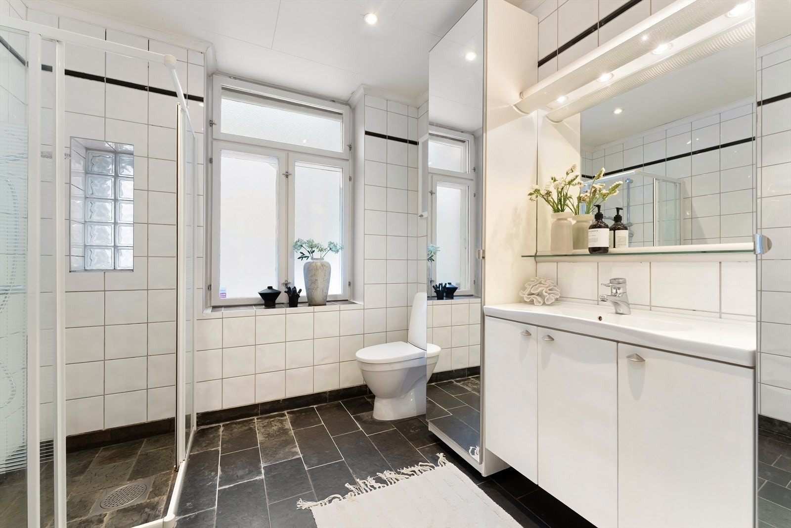 Stort, flislagt bad med dusj, servant, dusjhjørne og rikelig med oppbevaringsplass. Ny dusj i 2023. Galleribilde