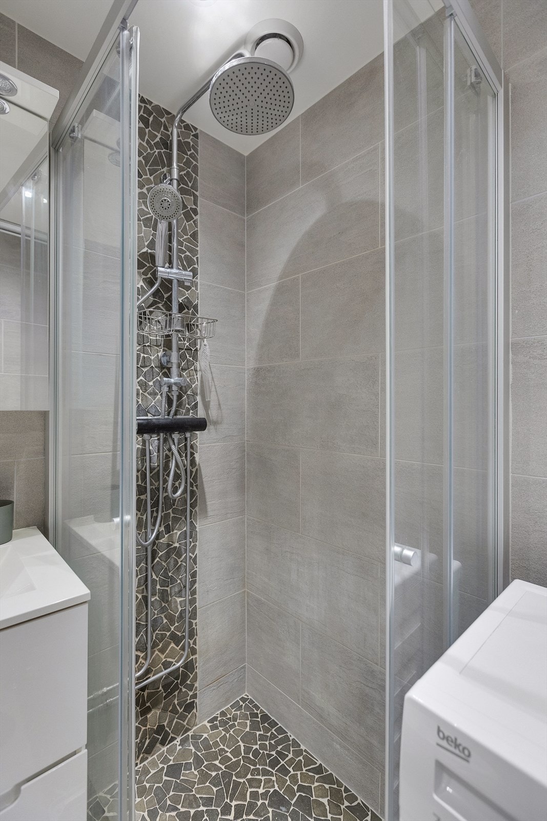 Badet er innredet med veggmontert WC, dusjplass med dusjvegger og servant med ettgreps blandebatteri i innredning. Galleribilde