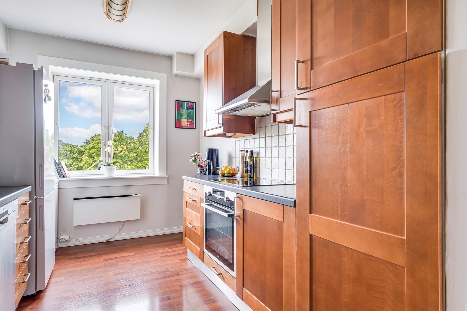 Kjøkkenet er utstyrt med medfølgende hvitevarer som nedfelt kokeplatetopp, integrert stekeovn, oppvaskmaskin og frittstående kjøleskap med frysedel. Galleribilde