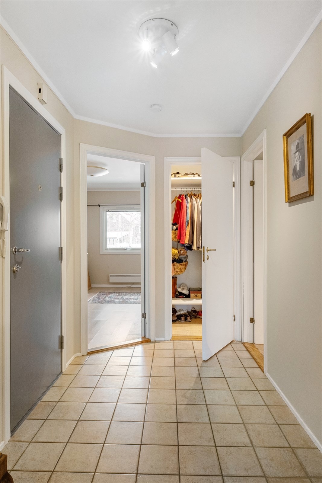 Lys og luftig entrè med flislagt gulv -tilknyttet med praktisk bod for oppbevaring av ytterklær og sko. Galleribilde