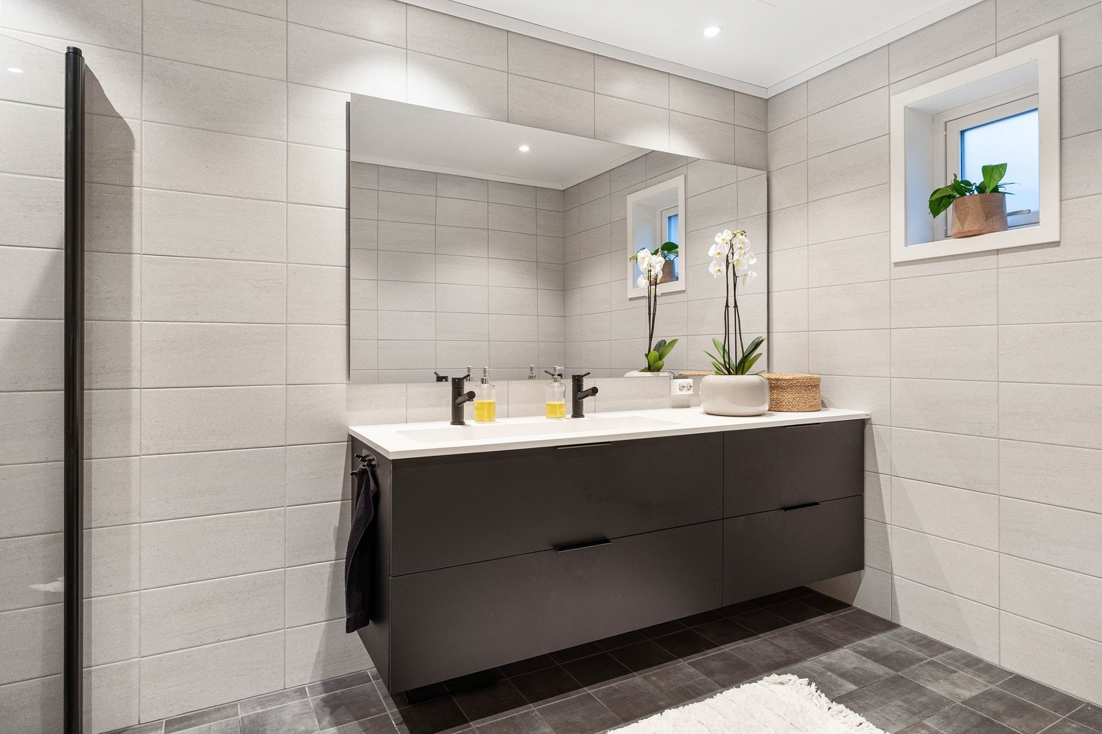 Romslig baderomsinnredning med dobbelvask og stort speil Galleribilde