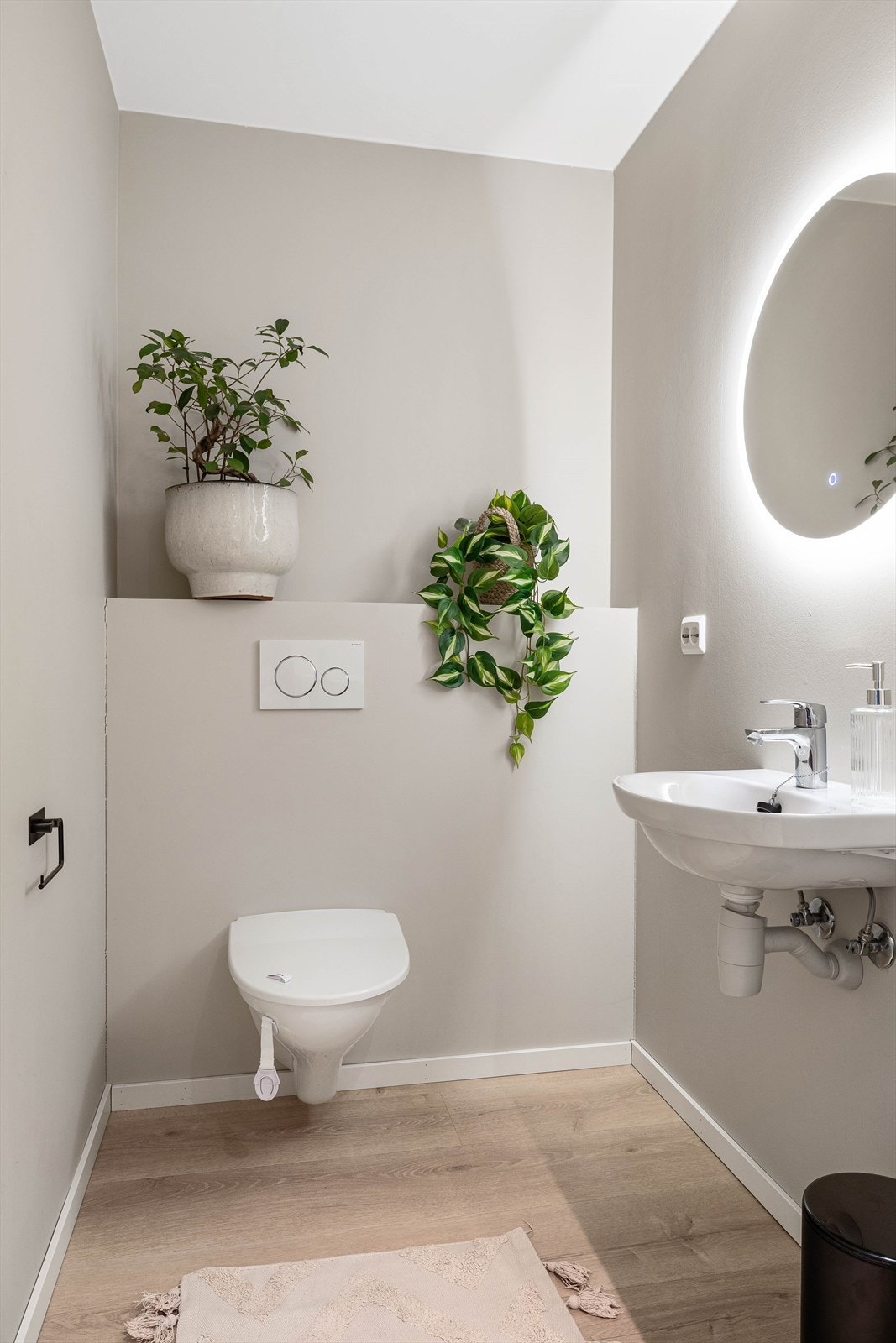 Toalettrom med vegghengt toalett og speil med belysning Galleribilde