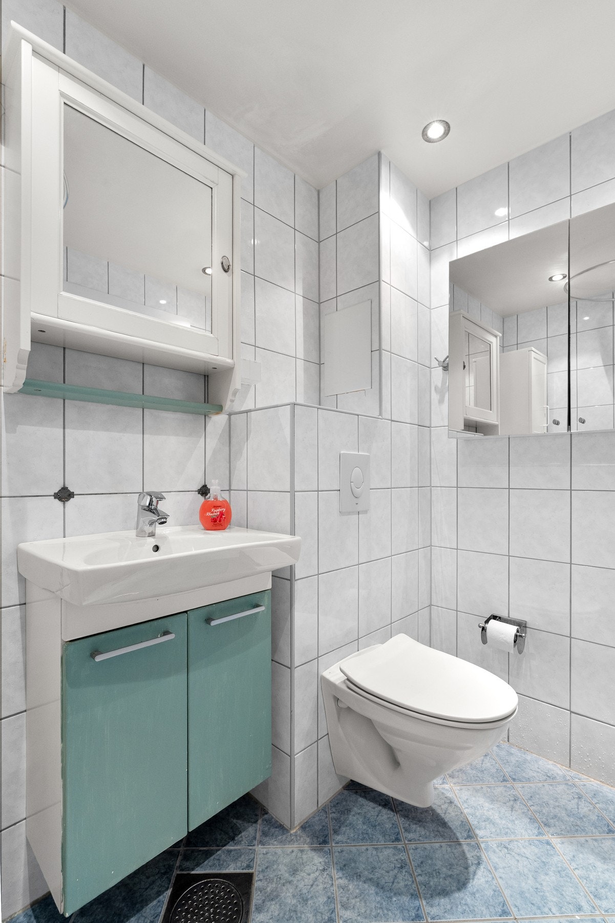 Baderomsinnredning med glatte fronter og ovenpåliggende servant, samt 2 vegghengte speilskap. Galleribilde