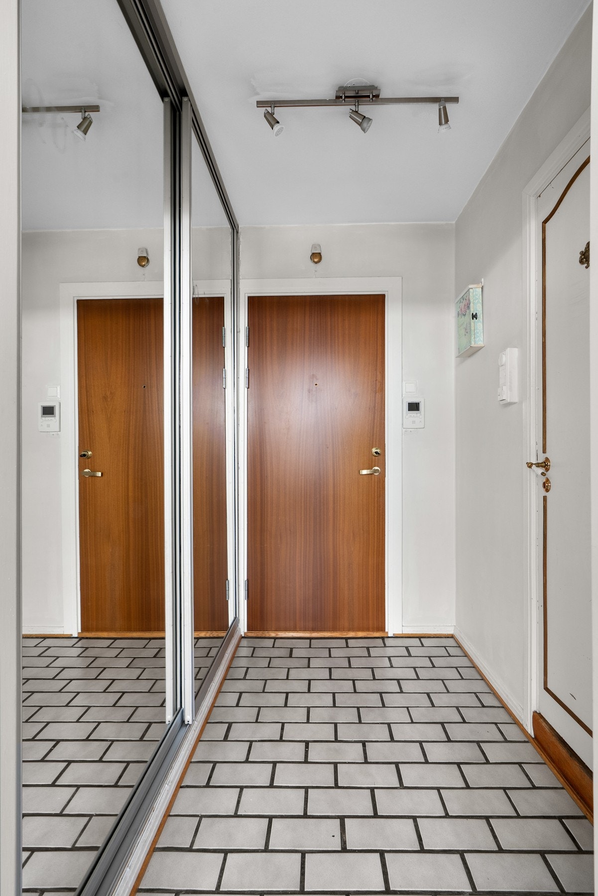 Montert porttelefon på vegg ved inngangsdøren og sikringsskap med automatsikringer i felles trappegang. Galleribilde