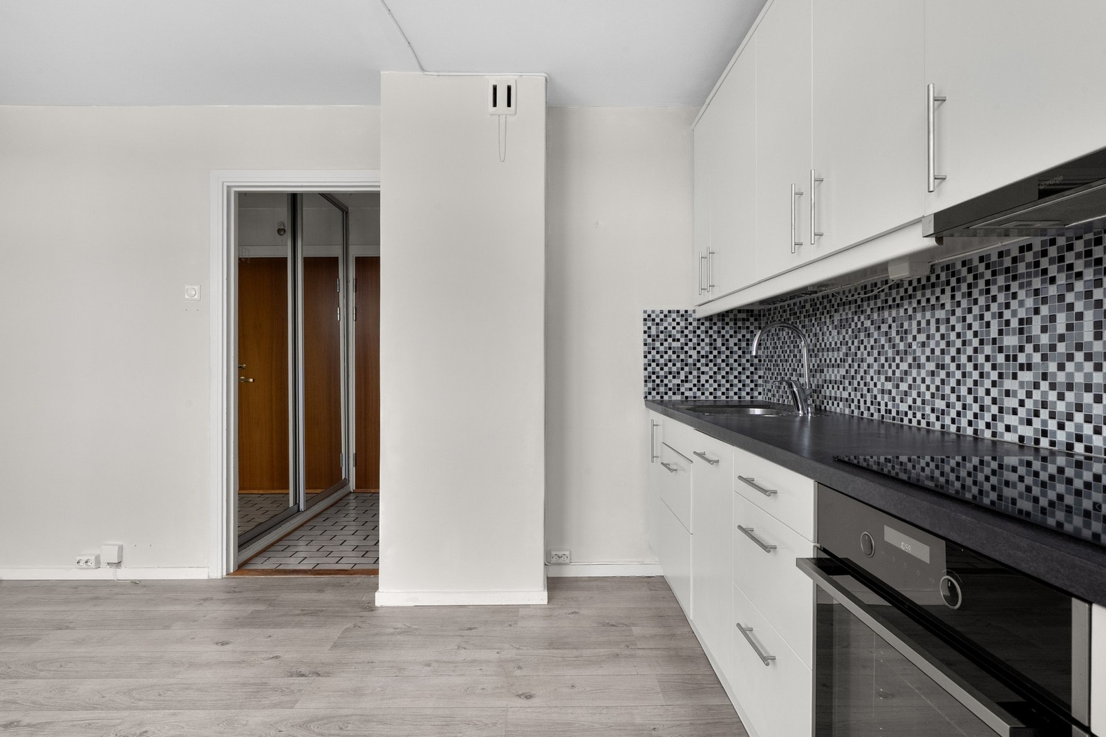 Praktisk med mosaikkfliser i benkeryggen og belysning under overskapene. Galleribilde