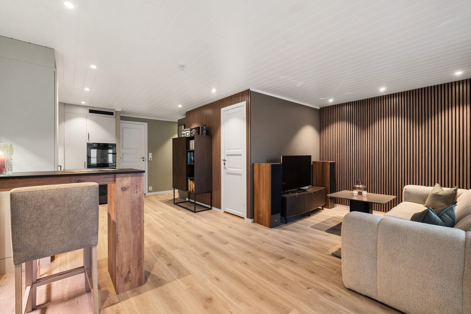 Oppholdsrommet har downlights i himling, 1-stavs laminat og varmefolie i gulv. Galleribilde