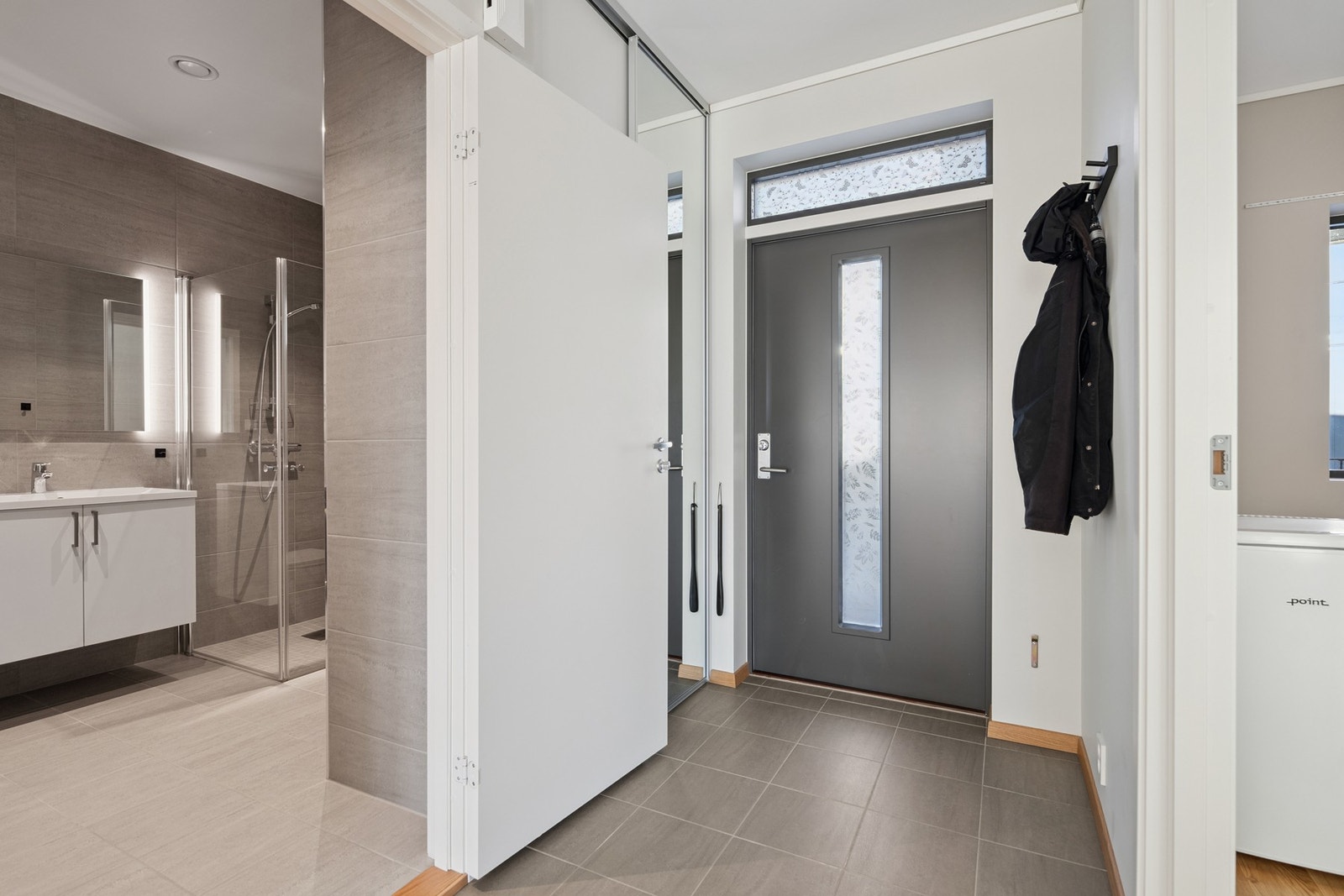 Romslig entré med tilhørende garderobeløsning og naturlig adkomst videre til boligens oppholdsrom. Galleribilde