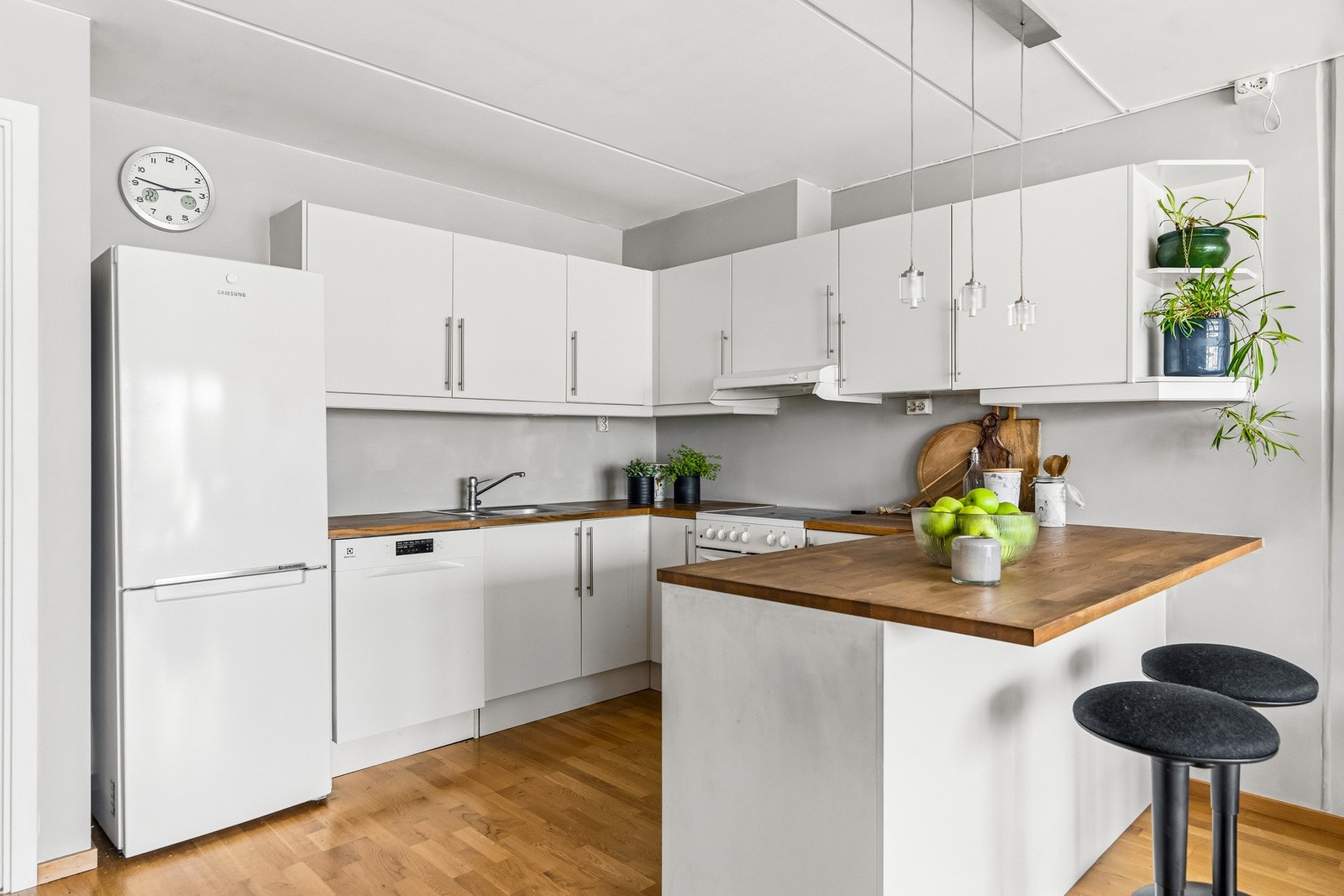 Kjøkkenet har en kjøkkeninnredning med glatte fronter og heltre benkeplate med planlimt kum i rustfritt stål samt ventilator. Galleribilde