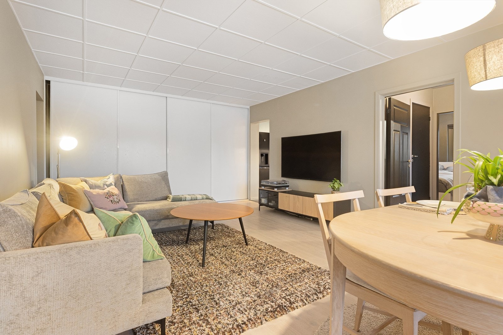 Rommet er av god størrelse og tillater plass til både sofagruppe med tilhørende bord og mediebenk, samt en romslig spisegruppe. Galleribilde