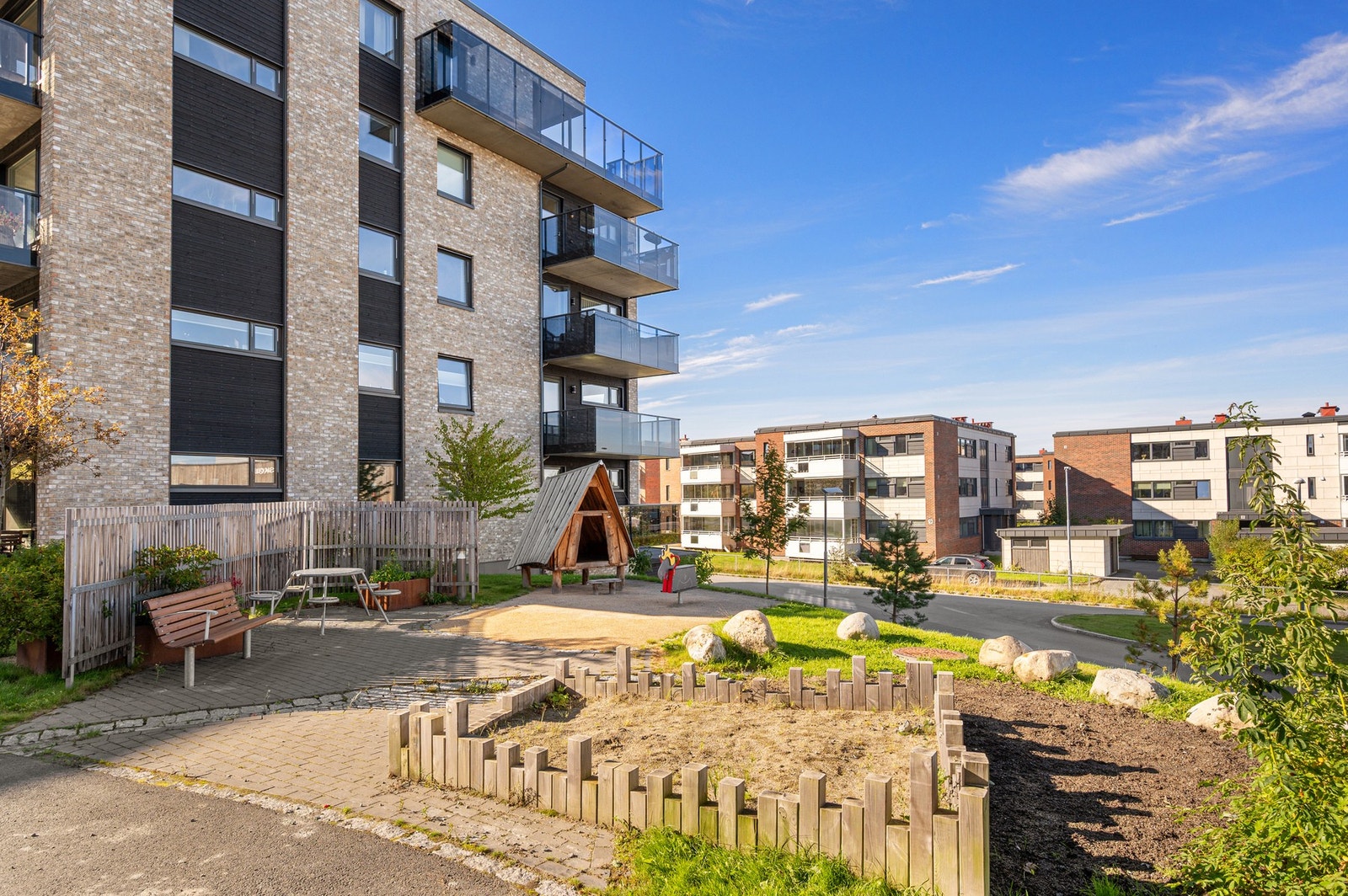 Fellesarealet er pent opparbeidet med lekeplasser, grøntareal og sittegrupper. Galleribilde