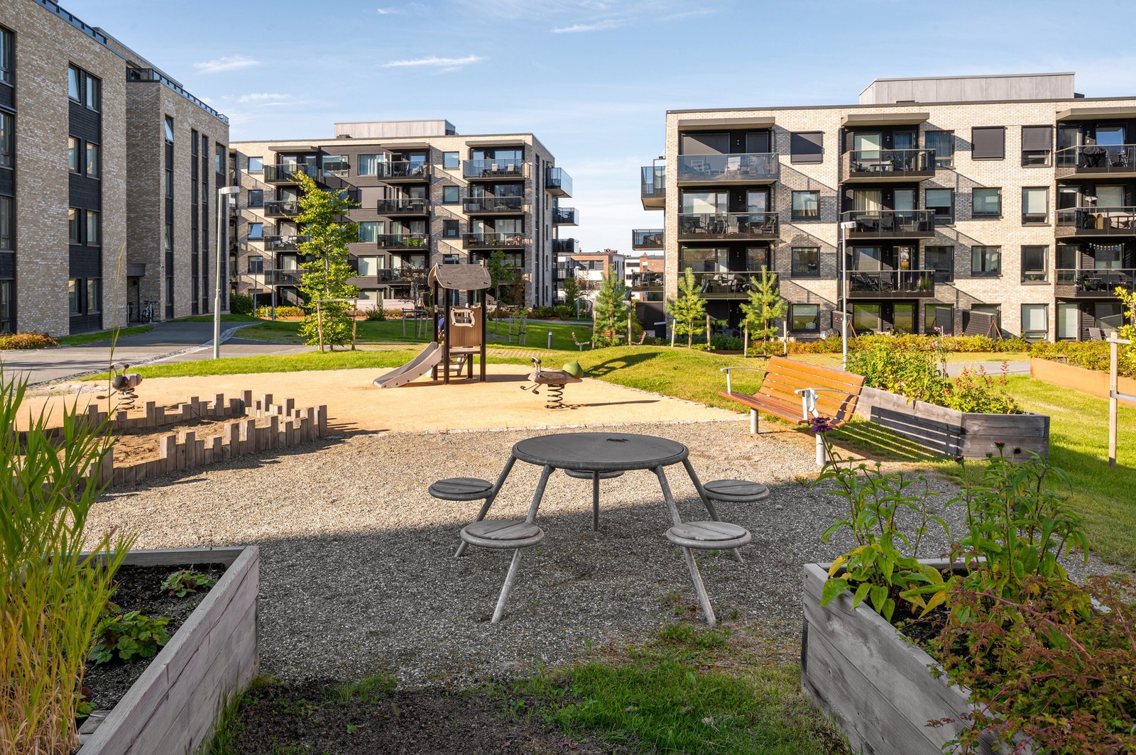 Fellesarealet er pent opparbeidet med lekeplasser, grøntareal og sittegrupper. Galleribilde