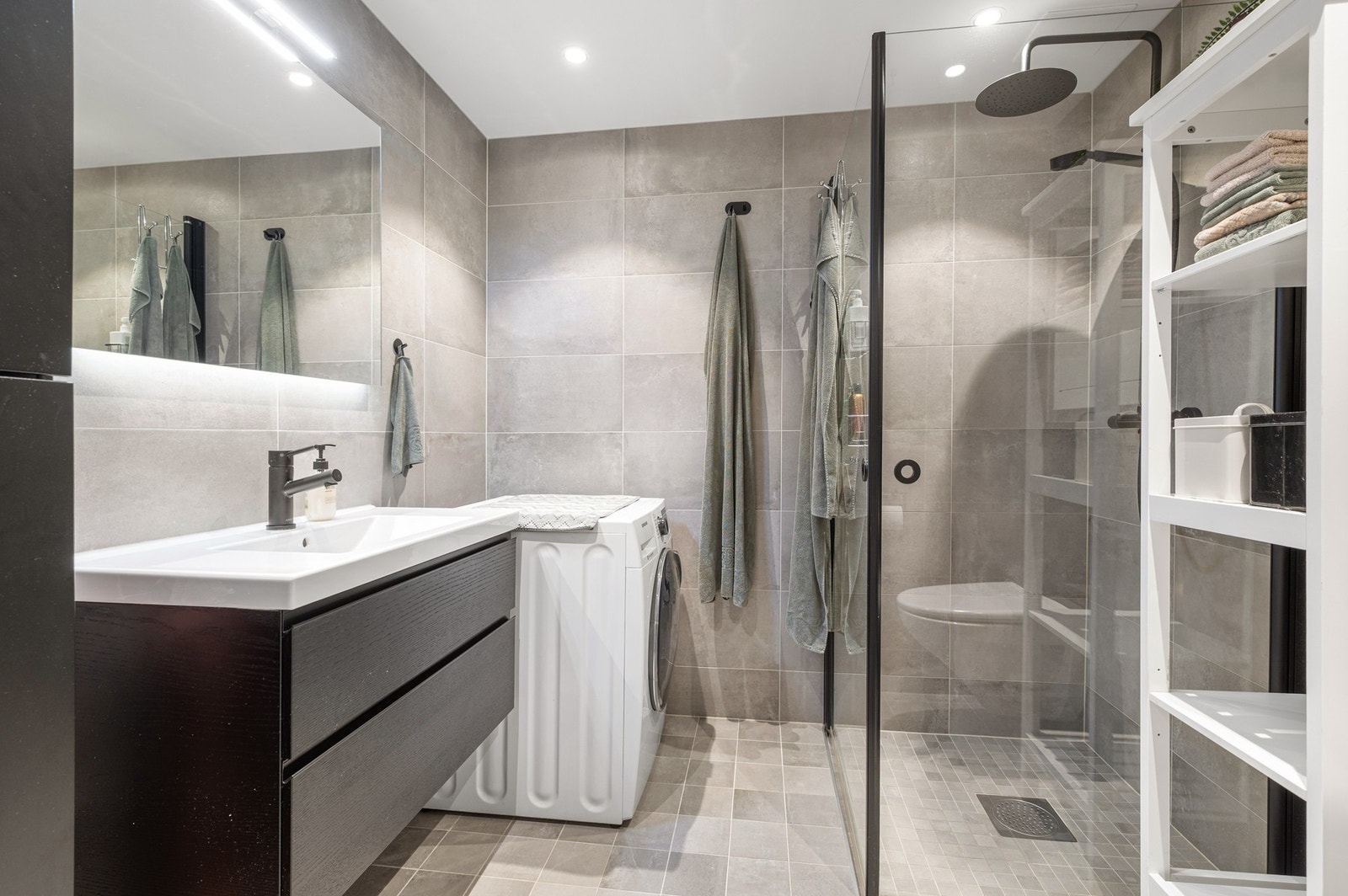 Moderne og stilrent bad. Det er opplegg for vaskemaskin. Varme i gulv og downlights i himling. Galleribilde