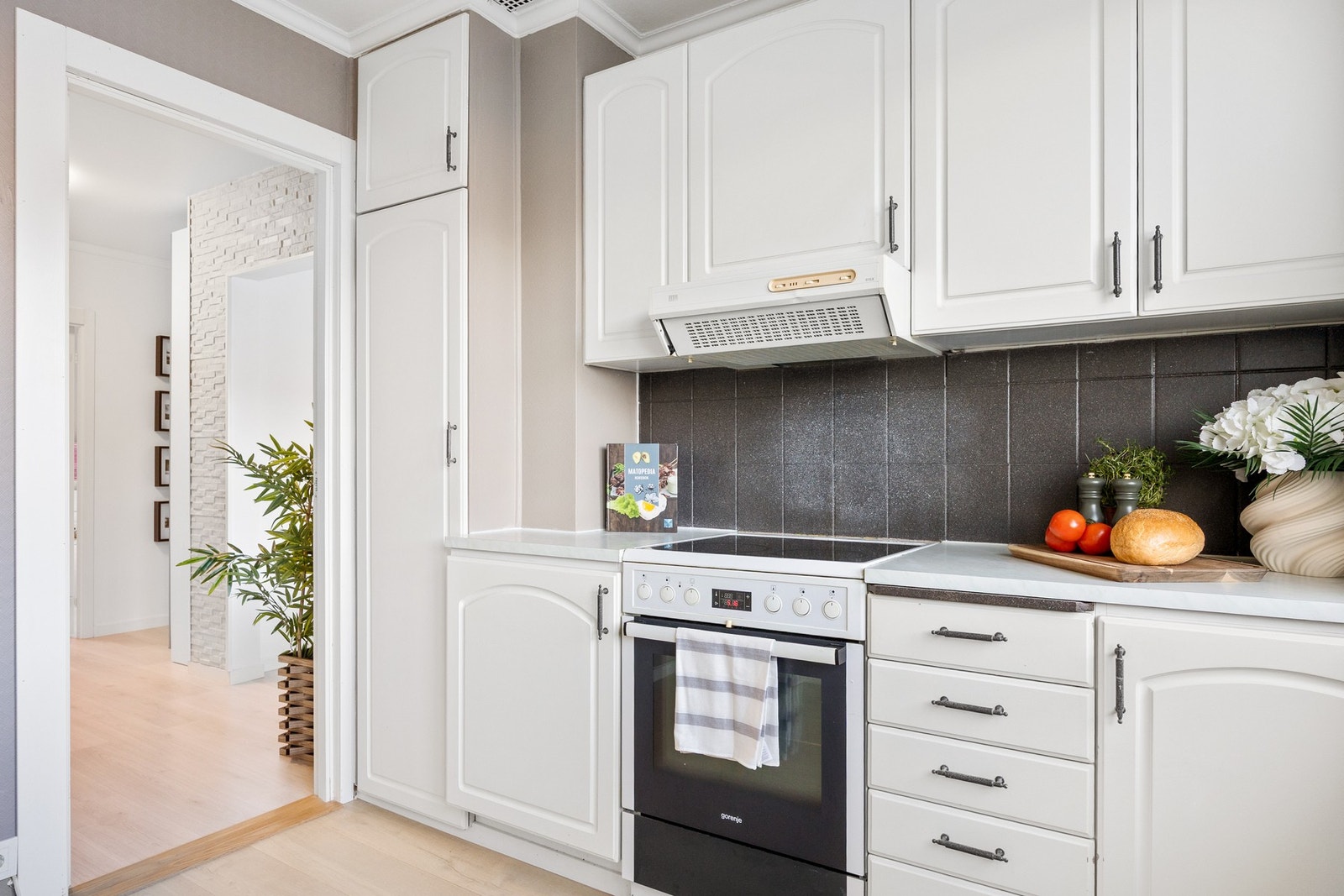 Kjøkkenet har innredning med profilerte fronter og laminert benkeplate Galleribilde